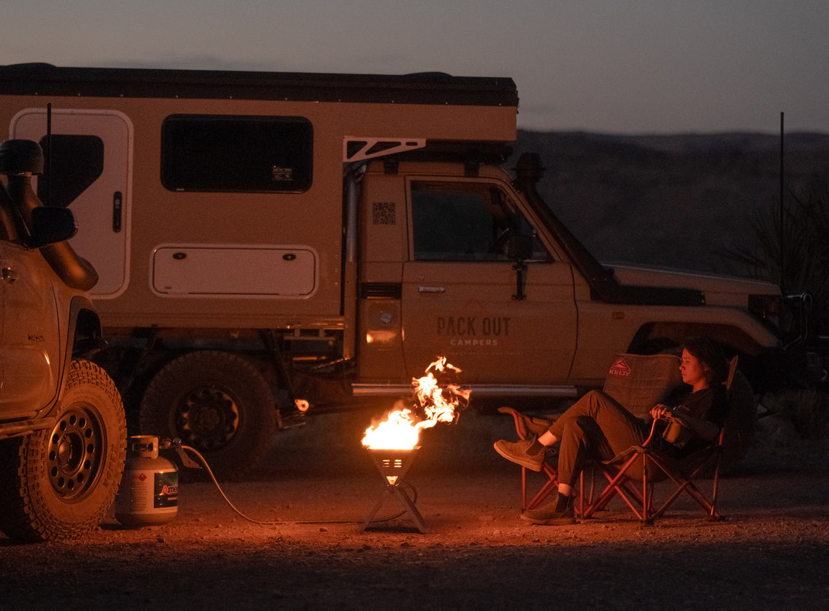 A camper and truck at a night camp lit by an RTE FireFold